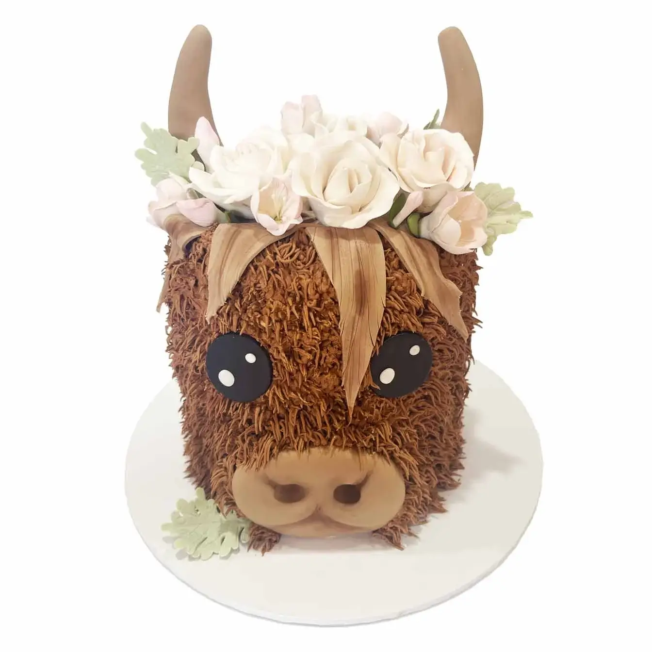 Majestic Highland Cow Cake - A double-height cake with piped fur, fondant facial features, and delicate fondant flowers on its head, reminiscent of the enchanting Scottish Highlands