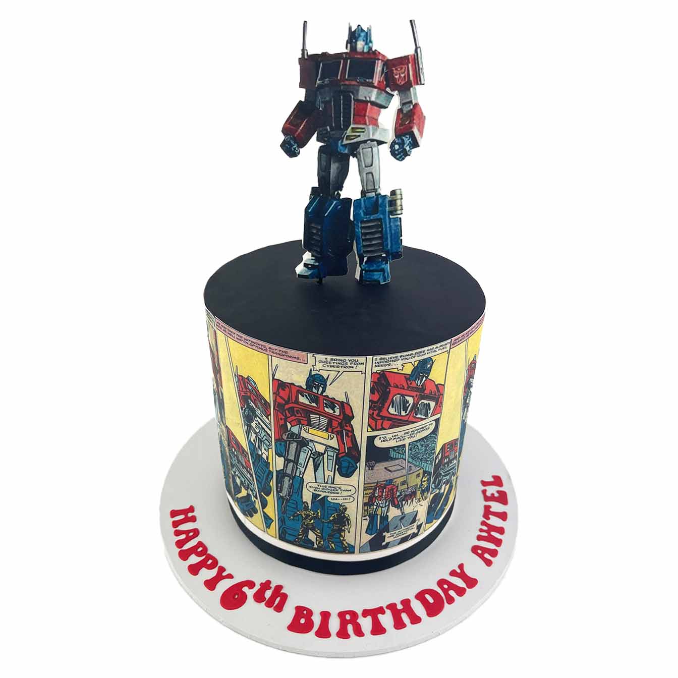Optimus Prime Power Cake - A double-height cake with 2D standing edible image of Optimus Prime on top and comic book-style image wrap, a thrilling centrepiece for Transformers fans.