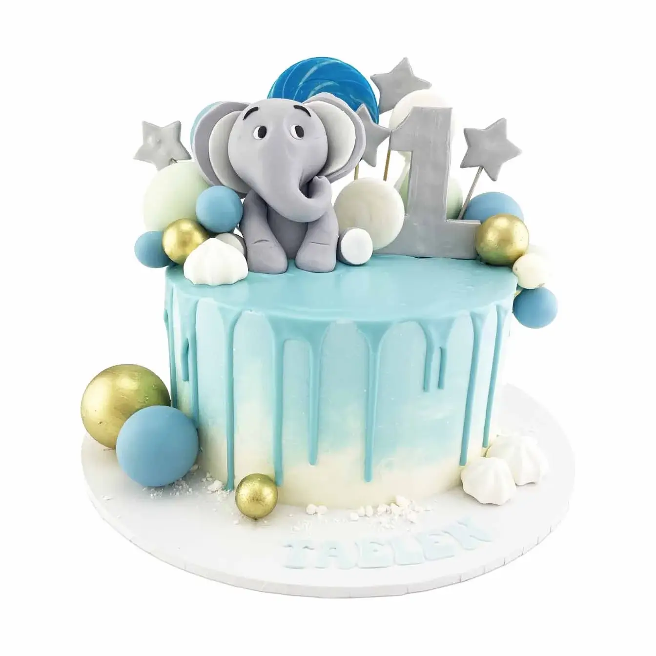 Blue ombre baby elephant drip cake with moulded elephant on top, chocolate spheres, lollipops, and meringues as decorations.