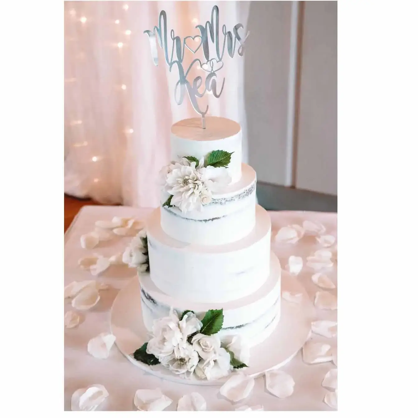 Elegance in Layers Wedding Cake - A four-tier semi-naked wedding cake with a personalized cake topper, a timeless centerpiece for weddings filled with love and commitment.