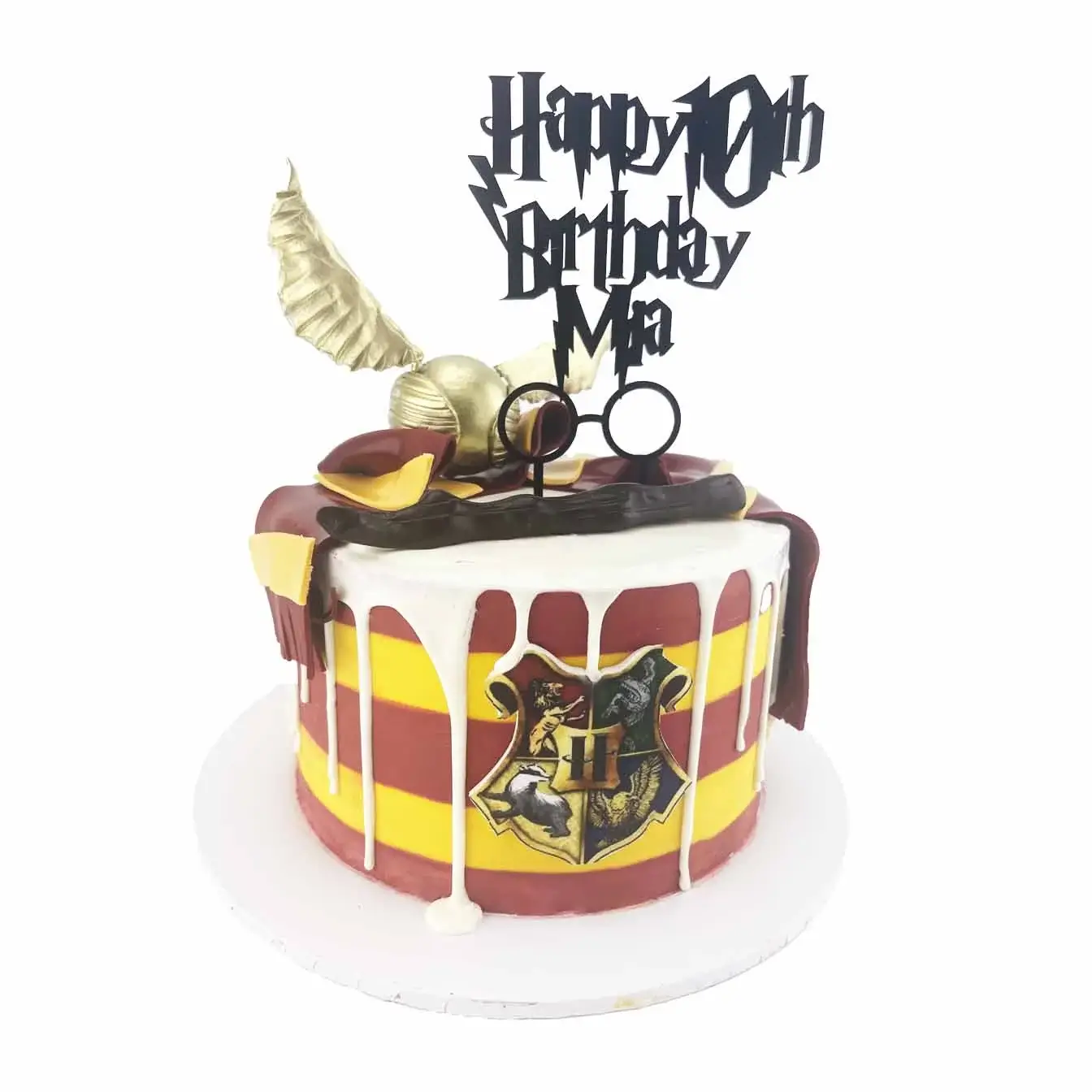 A Harry Potter-themed cake with a fondant magic wand, personalized cake topper, golden snitch, and Hogwarts house scarf. Perfect for any celebration!