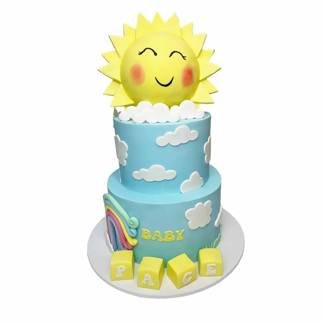 Ray of Sunshine Baby Shower Cake - A two-tier blue fondant cake with cutout clouds, baby name blocks, and a moulded round smiling sun on top, a delightful centerpiece for a joyous baby shower celebration.