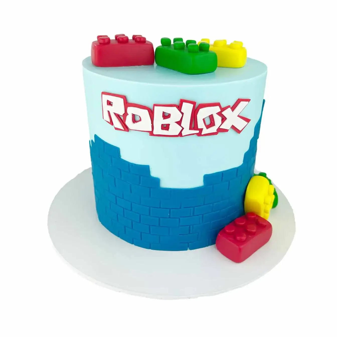 Roblox Adventure Block Cake - A blue-iced cake with multicolored bricks on top and the iconic Roblox logo on the front, a flavorful centerpiece for gamers and Roblox enthusiasts.
